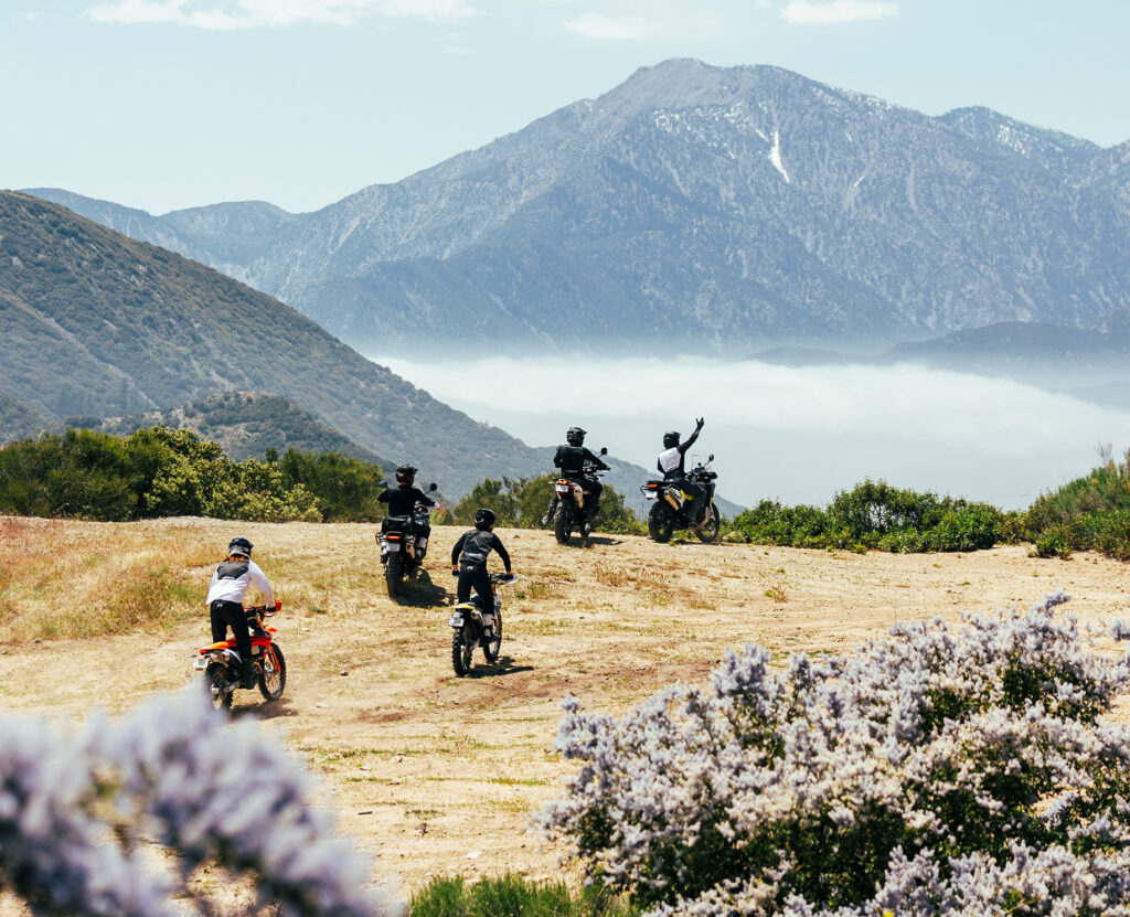 Motorbike on a dirt trail with misty mountains in the background.