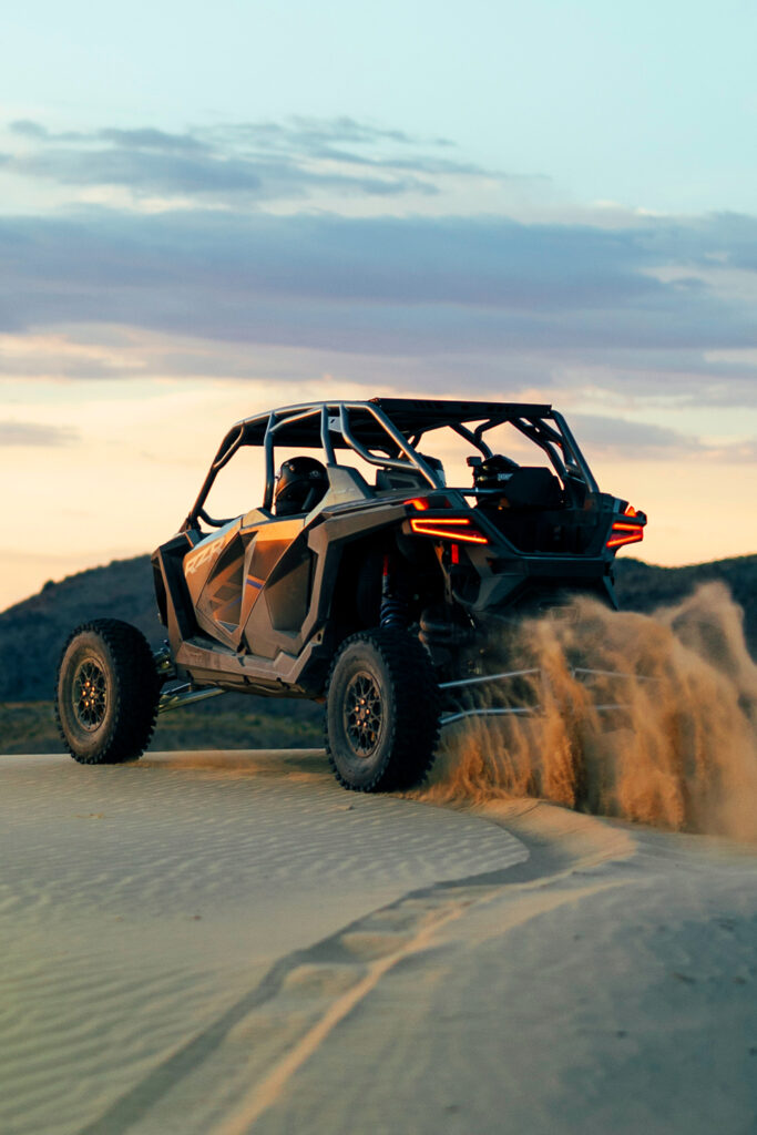 Polaris RZR Overlooking a Sandy Cliff Watching Stunning Sunset